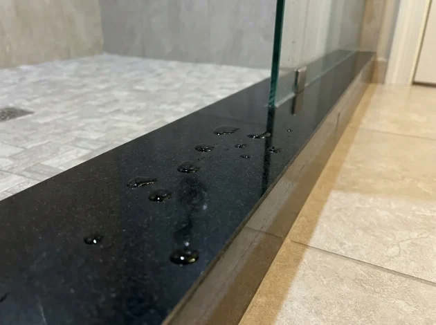Black Absolute Granite threshold used as a shower curb in a walk-in shower